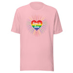 A pink crew neck unisex t-shirt featuring a design of a vibrant rainbow-striped heart at the center with the text "love is love" written inside. Around the heart colorful, radiating lines, with sunburst effect emphasizing inclusivity and love for all.