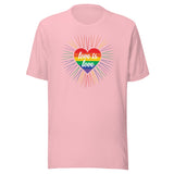 A pink crew neck unisex t-shirt featuring a design of a vibrant rainbow-striped heart at the center with the text "love is love" written inside. Around the heart colorful, radiating lines, with sunburst effect emphasizing inclusivity and love for all.