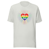 A silver crew neck unisex t-shirt featuring a design of a vibrant rainbow-striped heart at the center with the text "love is love" written inside. Around the heart colorful, radiating lines, with sunburst effect emphasizing inclusivity and love for all.